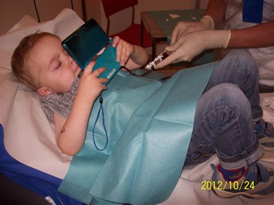 Filip med sitt nya spel, när han är på en av sina många behandlingar på Kalmar sjukhus.